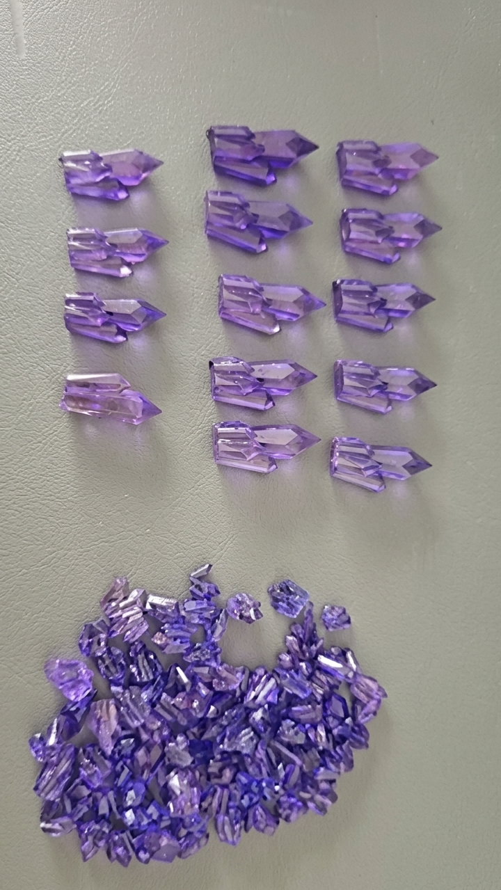Collection of purple crystal points on a light gray background
